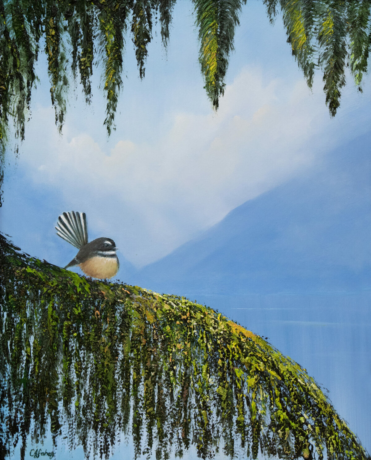 A Piwakawaka Fantail perches on a moss-covered branch, enveloped by hanging foliage, with a serene blue sky and distant mountains in the background.