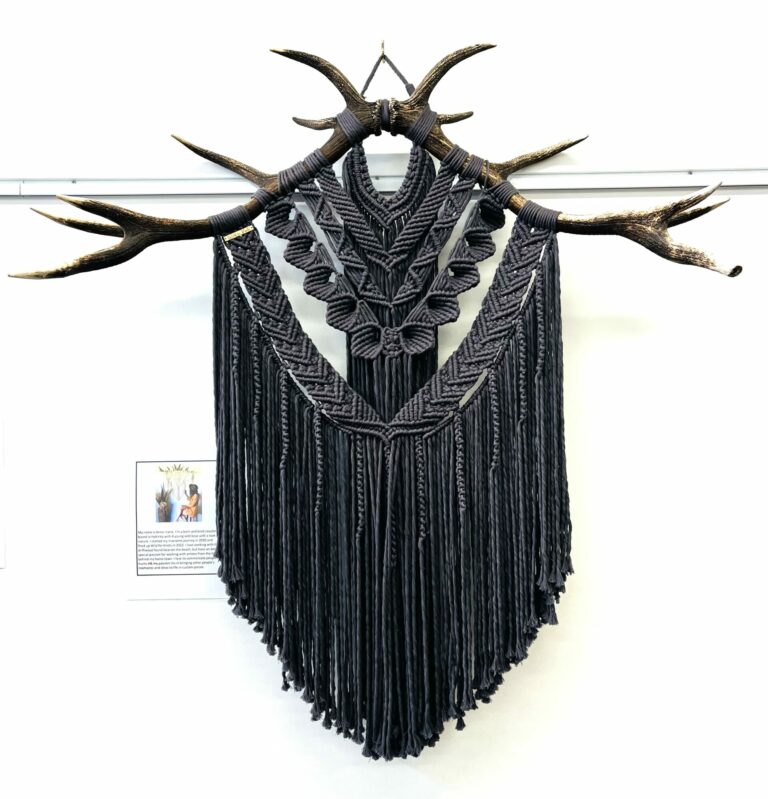 The Macrame deer antler features intricate black knotting and fringe.