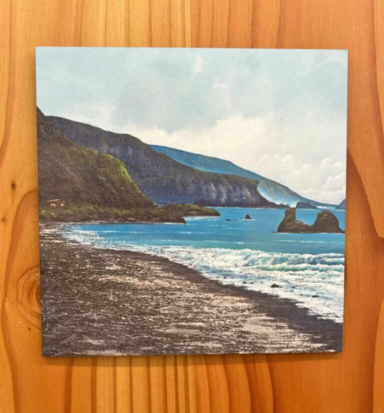 Displayed on a wooden surface, "The Great Coast Road 14mile Wall Tile" features a painting of a coastal landscape with cliffs, a rocky beach, and waves under a partly cloudy sky.